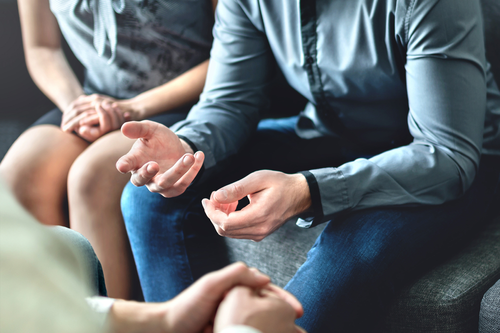 The hands of 2 people having a difficult conversation.